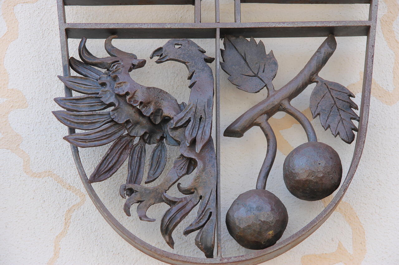 Bild vergrößern: Geschmiedetes Wappen am Rathaus mit Doppeladler und Kirschenzweig